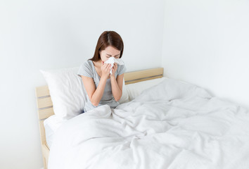 Woman sneeze on the bed