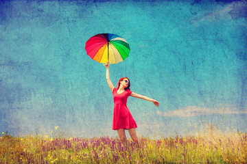 girl in red dress with umbrella on meadow