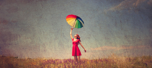 girl in red dress with umbrella on meadow