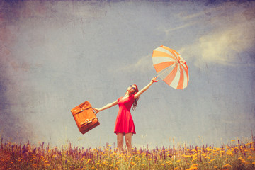 girl in red dress with umbrella and suitcase