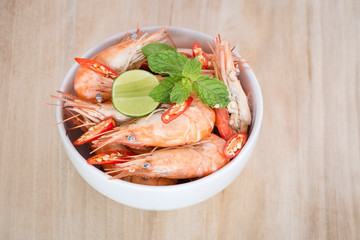 Shrimps and lemon in white bowl
