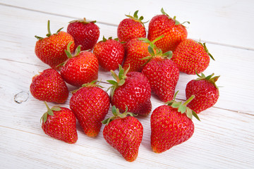 Strawberries on the white wood board