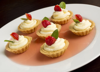 Cakes with strawberry, whipped cream, jelly and mint
