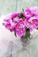 Pink peonies on wooden background