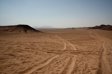 Fototapeta na wymiar Pustynny krajobraz - ślady samochodów na piasku