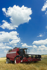 Fototapeta premium Combine machine with header or cutting blade standing in oat farm field