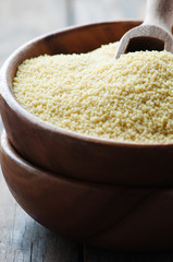 Uncooked couscous on the wooden table