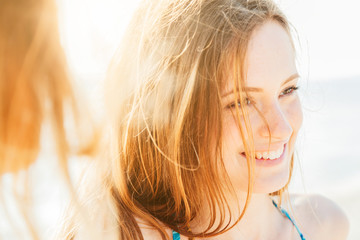Portrait of a smiling woman on the beach at sunset