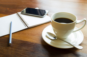 Coffee cup with smart phone,pencil and book.