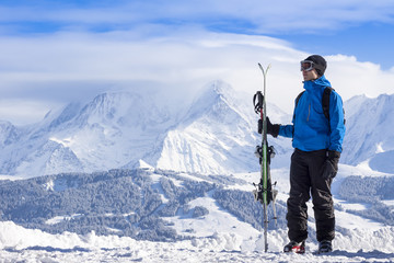 Skier holding skis in hand
