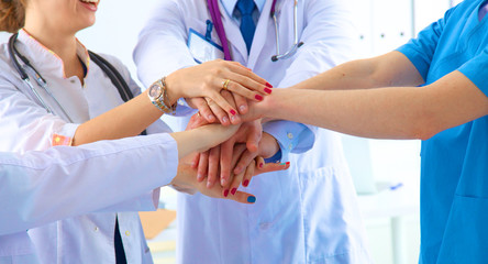 Doctors and nurses in a medical team stacking hands 