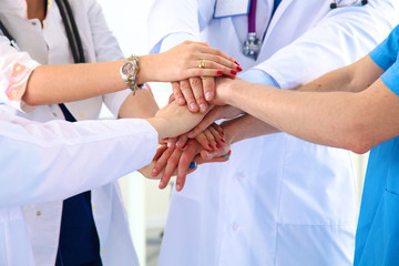 Doctors and nurses in a medical team stacking hands 