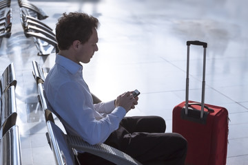 Businessman using smartphone at airport