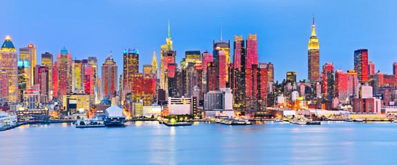 Fototapeta na wymiar Panoramic view of Manhattan skyline with red sunlight reflection.