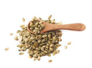 Wooden spoon over pumpkin seeds