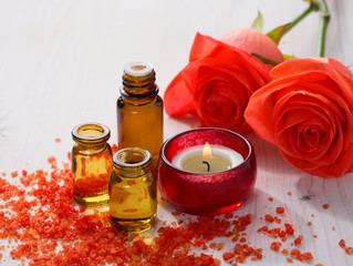 Essential oil, Mineral bath salts, candle and flowers on the wooden table.
