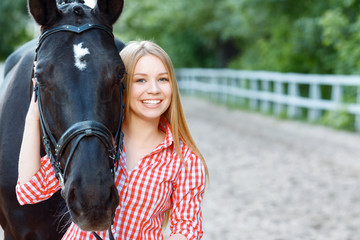 Smiling girl taking care of the horse