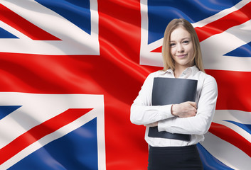 Smiling business lady in a white shirt with a black folder. Great Britain flag as a background.