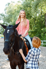 Smiling girl sitting in the saddle 