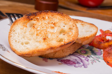 a slice of toasted bread crust with tomato sauce