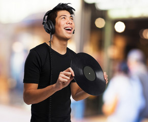 chinese man with headphones and vinyl