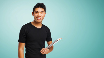 young chinese man holding his notebook