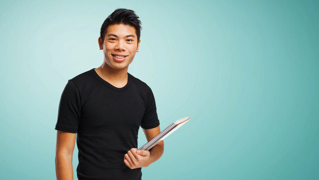 young chinese man holding his notebook