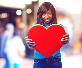 pensive black woman holding a heart