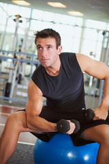 Fototapeta na wymiar Gym: Muscular Man Working Out With Dumbbells
