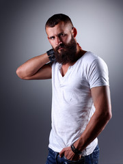 Portrait of handsome bearded man standing, isolated on grey
