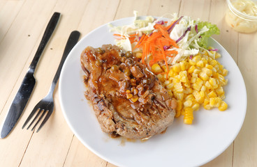 Beef Steak on white dish, plank wood background.