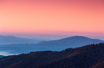 Beautiful landscape at dawn. Layers of mountain in pink light.