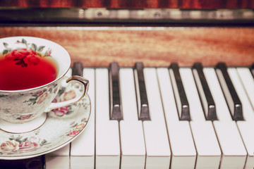 A cup of tea and a piano in a vintage toning