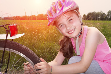 Bambina con casco e bicicletta