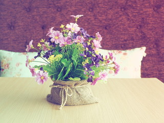 Vintage Artificial flowers on wood table.