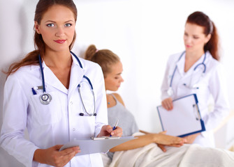 Smiling female doctor with a folder in uniform standing at