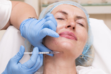Naklejka premium Cosmetic treatment with injection in a clinic