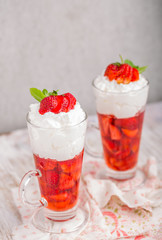 Strawberries in jelly topped with whipped cream