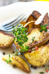 Baked new potatoes with herbs on a wooden background