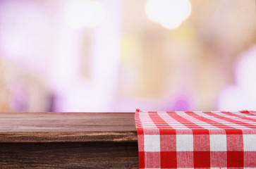 Empty wooden table with napkin and light background