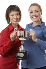 two business woman holding up a trophy