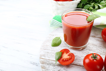 Glass of fresh tomato juice on wooden table, closeup