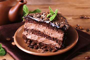 Delicious chocolate cake with mint on plate on table close up