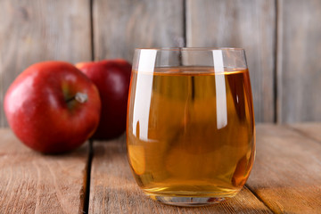 Glass of apple juice on wooden background