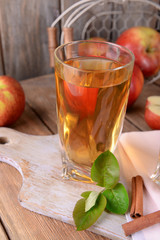 Glass of apple juice on wooden background