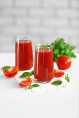Tomato juice and fresh tomatoes on wooden table close-up