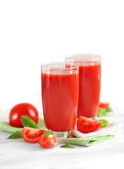 Tomato juice and fresh tomatoes on wooden table close-up