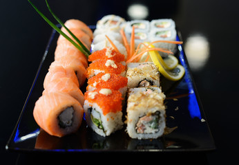 Japanese sushi on a black plate.