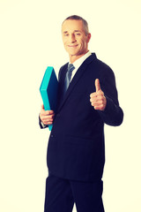 Mature businessman with ok sign holding a binder