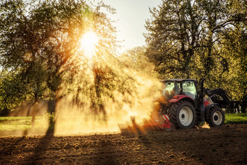 Tractor ploughing a field at sunset